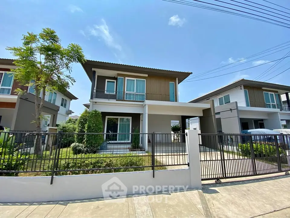 Modern two-story house with garden and driveway in a sunny neighborhood.