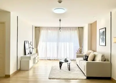 Spacious and bright living room with modern decor and large windows.