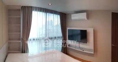 Modern bedroom with large window, built-in shelves, and wall-mounted TV in urban apartment.