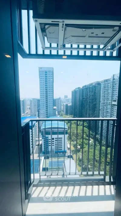 Stunning high-rise balcony view with modern cityscape and lush greenery, perfect for urban living enthusiasts.