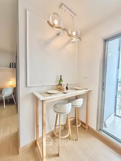 Chic modern dining nook with stylish lighting and balcony access