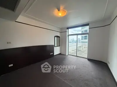 Spacious room with large window and balcony access in modern apartment
