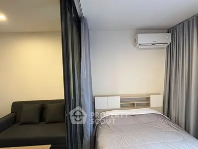 Modern bedroom with air conditioning and cozy sofa in a stylish apartment.