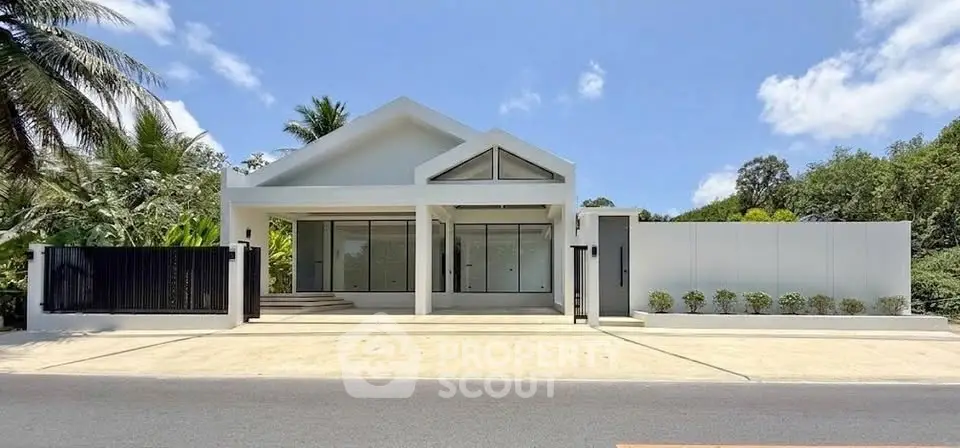 Modern minimalist white house with sleek design and lush greenery, perfect for contemporary living.