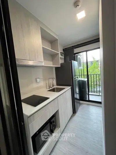 Modern kitchen with sleek appliances and balcony view in stylish apartment