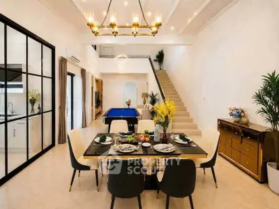 Luxurious open-plan dining and living area with elegant decor and pool table, perfect for entertaining.