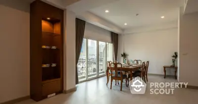 Spacious dining area with elegant wooden furniture and large windows offering city views.