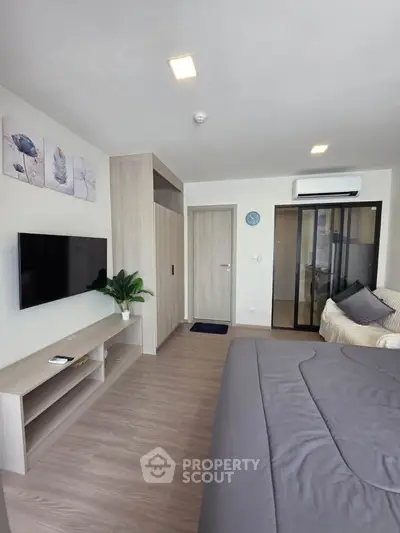 Modern bedroom with sleek design, featuring a wall-mounted TV, air conditioning, and stylish decor.