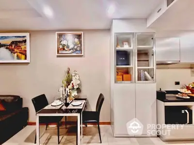 Modern and cozy open-layout kitchen with stainless steel appliances, adjacent to a stylish dining area, perfect for intimate dinners or entertaining guests.