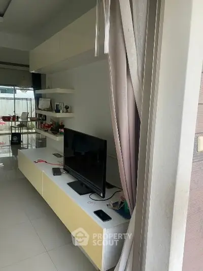 Modern living room with sleek TV unit and open shelves, perfect for contemporary living.