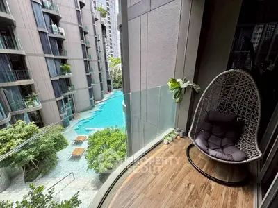 Luxurious balcony with stunning pool view in modern apartment complex.