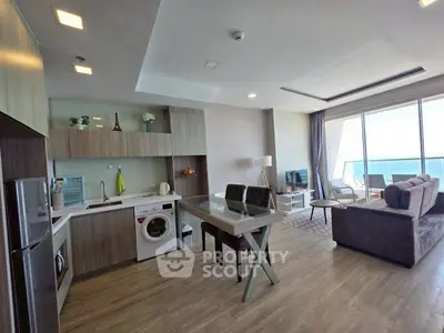 Modern open-layout living room with kitchen and ocean view balcony in luxury apartment