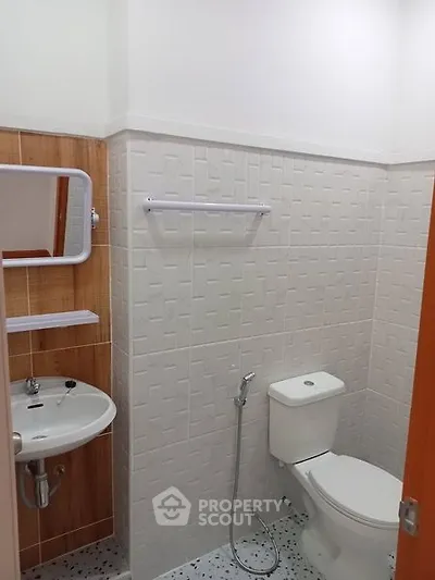 Modern bathroom with sleek fixtures and tiled walls, featuring a compact design.