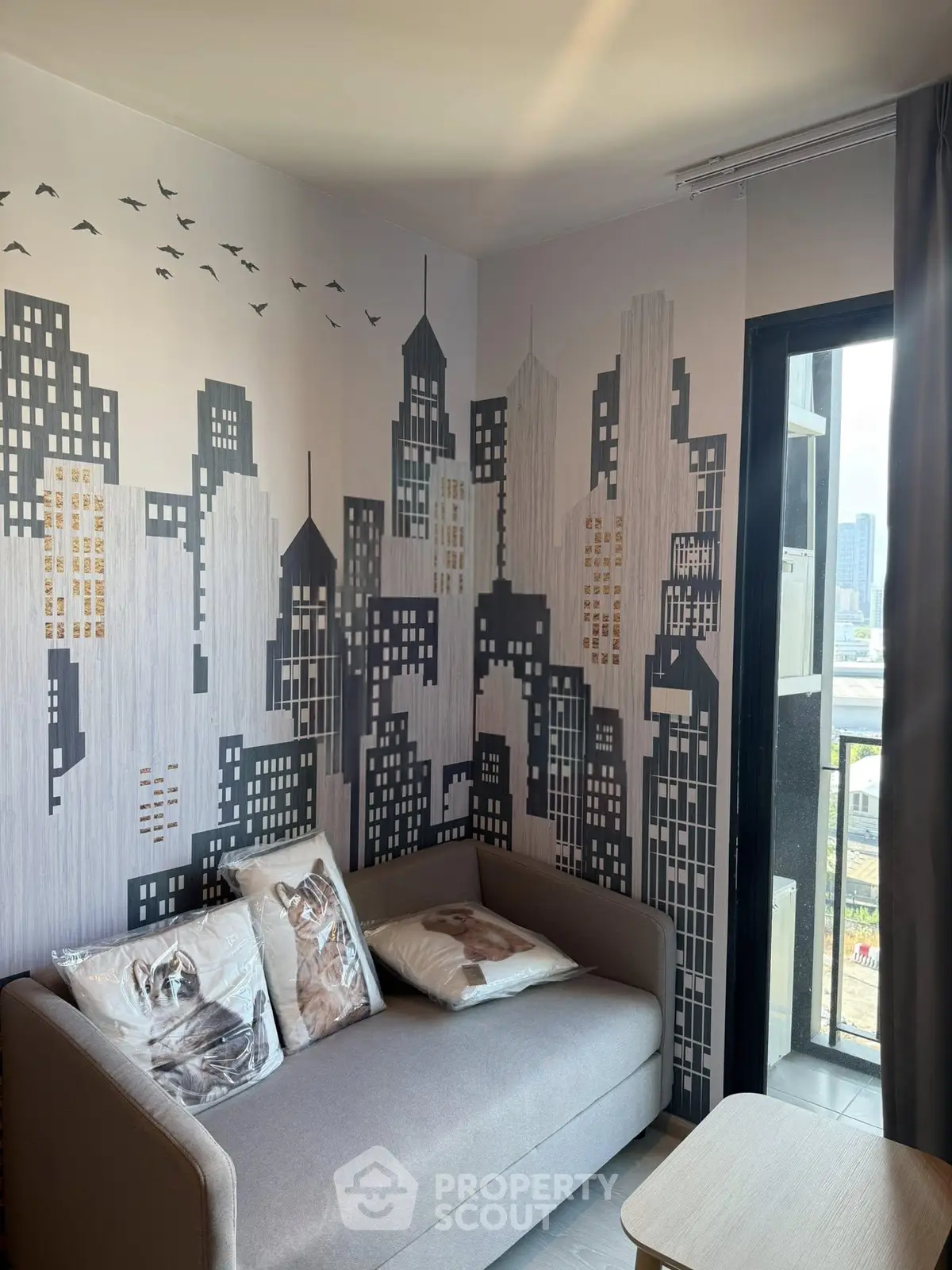 Modern living room with cityscape wall art and cozy sofa near balcony.