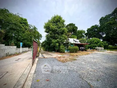 Spacious property with lush greenery and ample parking space, ideal for development or investment opportunities.