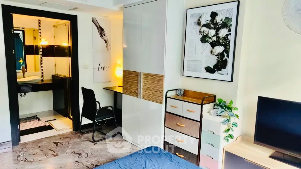 Stylish bedroom with modern decor and attached bathroom, featuring sleek furniture and elegant design.