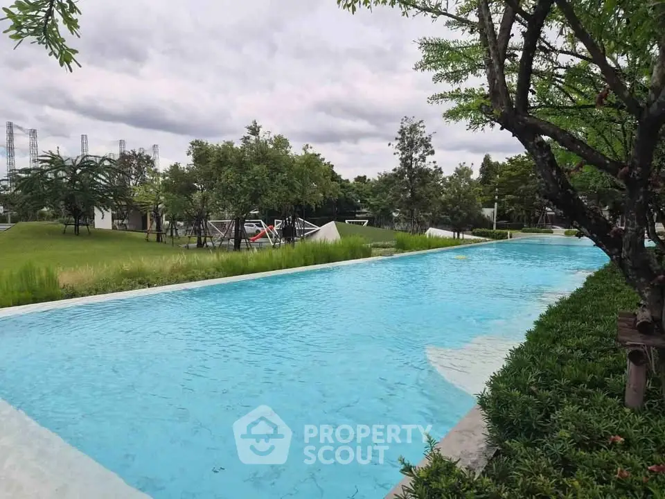 Luxurious outdoor pool with lush greenery and serene surroundings in a modern residential complex.