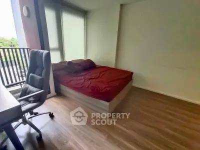 Modern bedroom with wooden flooring and balcony view in urban apartment
