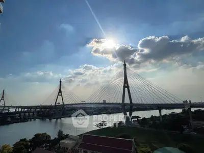 Stunning view of a modern suspension bridge over a river at sunset, perfect for urban living.