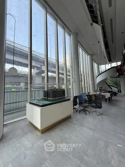 Spacious modern office space with floor-to-ceiling windows and urban view, ideal for businesses seeking natural light.