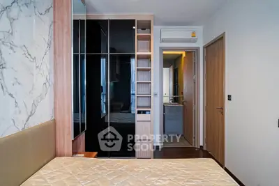 Modern bedroom with built-in wardrobe and ensuite bathroom in luxury apartment
