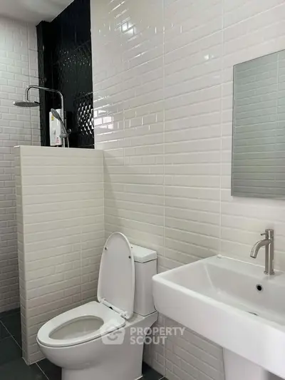 Modern bathroom with sleek white tiles and contemporary fixtures.
