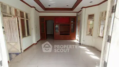 Spacious living room with large windows and built-in wooden cabinets