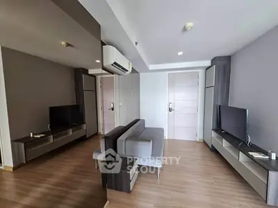 Modern living room with sleek furniture and dual TVs, featuring a stylish air conditioning unit.