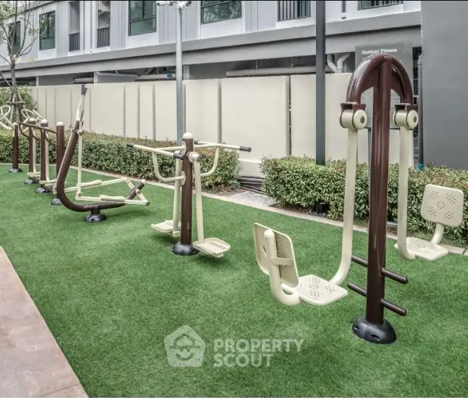 Modern outdoor fitness area with exercise equipment in a residential complex.