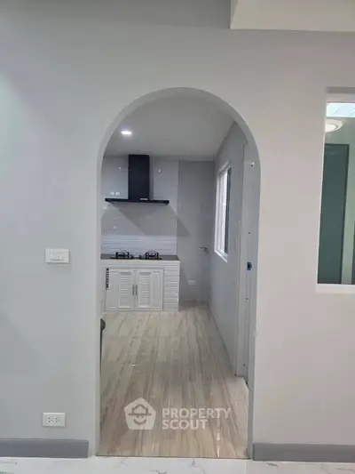 Modern kitchen with arched entry and gas stove in sleek minimalist design