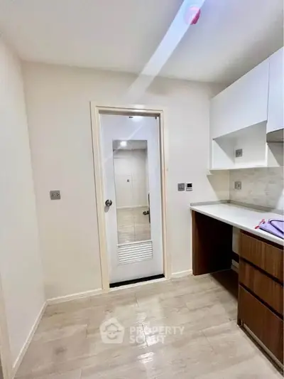 Modern kitchen with sleek cabinetry and wood flooring, perfect for culinary enthusiasts.