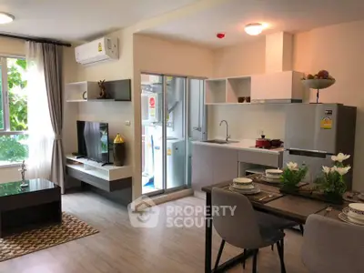 Modern open-plan living room and kitchen with stylish decor and natural light.