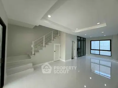 Spacious modern living room with staircase and large windows