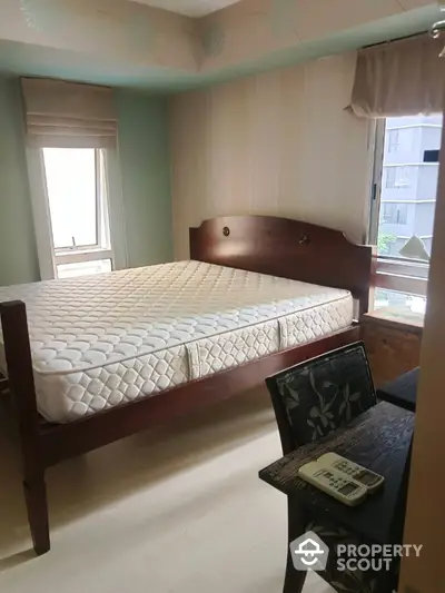 Cozy bedroom with wooden bed frame and natural light