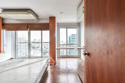 Spacious bedroom with city view and wooden flooring in modern apartment