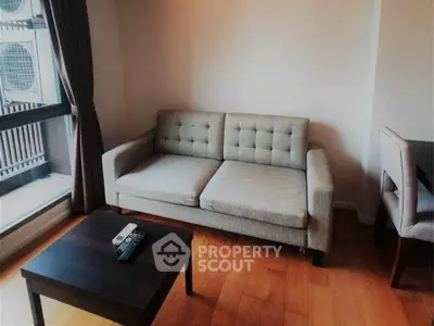 Cozy living room with modern sofa and wooden flooring, perfect for relaxation.