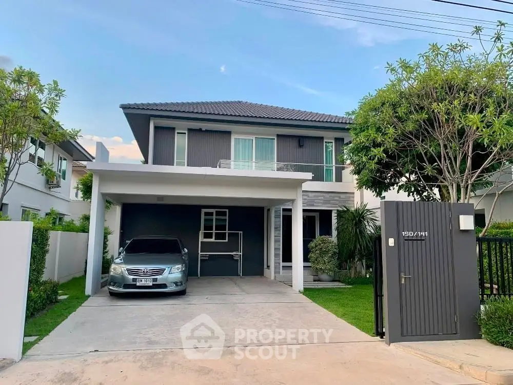 Modern two-story house with carport and lush garden in a serene neighborhood.