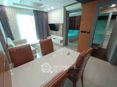 Modern open-plan living room with dining area and view into a stylish bedroom