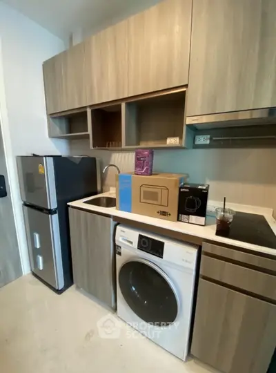 Modern kitchen with compact appliances and sleek wooden cabinetry