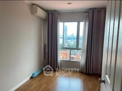 Bright bedroom with wooden flooring and large window offering city view
