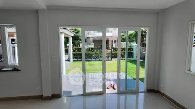 Spacious living room with sliding glass doors opening to a lush garden view.