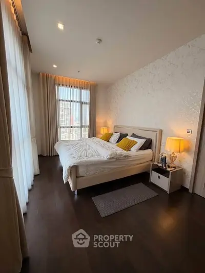 Luxurious bedroom with elegant decor and large window offering natural light.