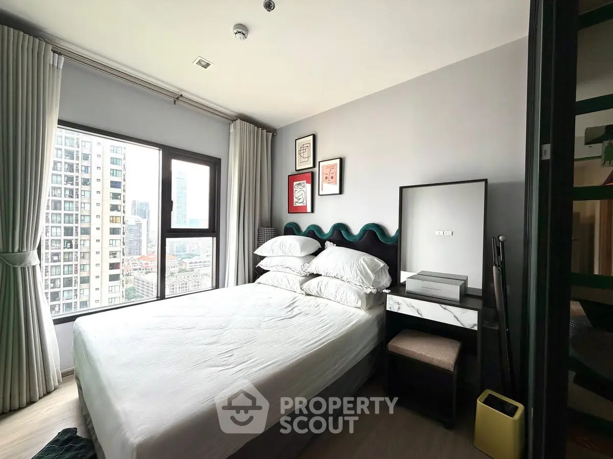 Modern bedroom with city view, stylish decor, and ample natural light.