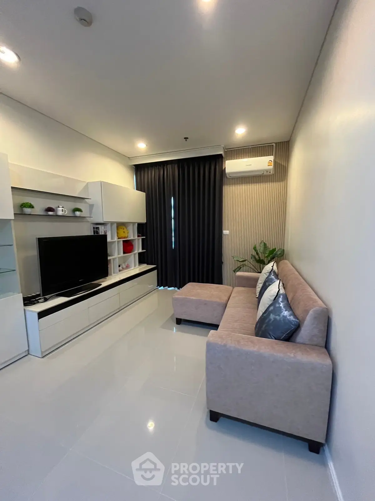 Modern living room with sleek furniture and stylish decor, featuring a cozy sofa and entertainment unit.