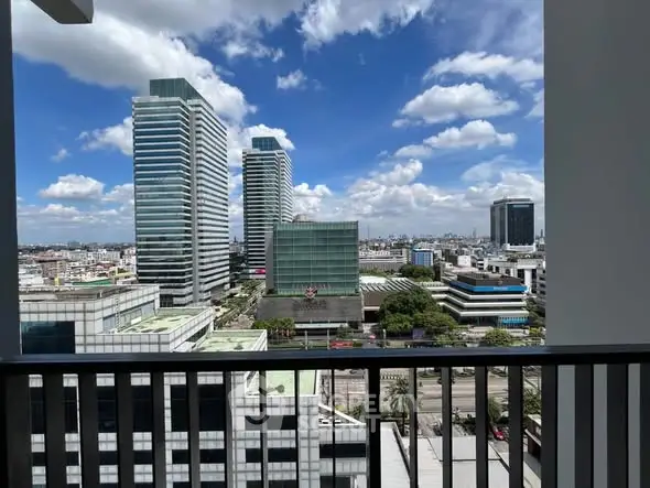 Stunning cityscape view from a modern balcony with blue skies and skyscrapers.