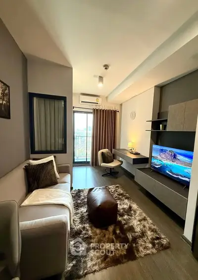Modern living room with cozy sofa, stylish decor, and large TV, perfect for relaxation and entertainment.