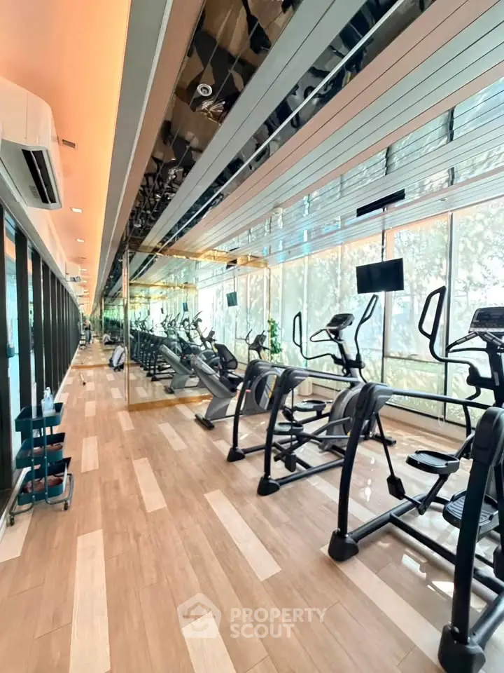 Modern gym with state-of-the-art equipment and mirrored walls in a luxury residential building.