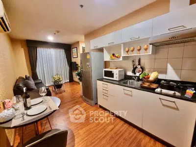 Modern kitchen with open layout and dining area, featuring sleek appliances and cozy decor.