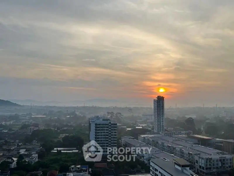 Stunning cityscape view with sunrise over urban skyline and distant hills.