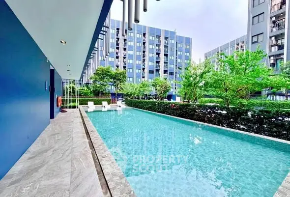 Modern apartment complex with a sleek outdoor pool and lush greenery.